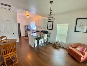 Relax in this open-plan living space with a central kitchen island, dining area, and cozy seating area.
