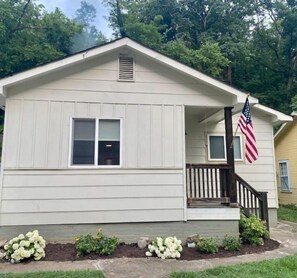 Cozy home with a front porch and garden, perfect for relaxation.