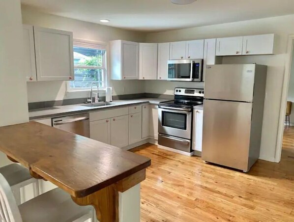 Enjoy cooking in this well-equipped kitchen with a central island, stainless steel appliances, and ample cabinetry.