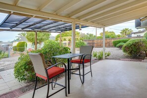 Relax in a serene outdoor space surrounded by lush greenery and a wooden pergola.