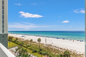 A beach with a clear sky, a sandy shore, and a view of the ocean.