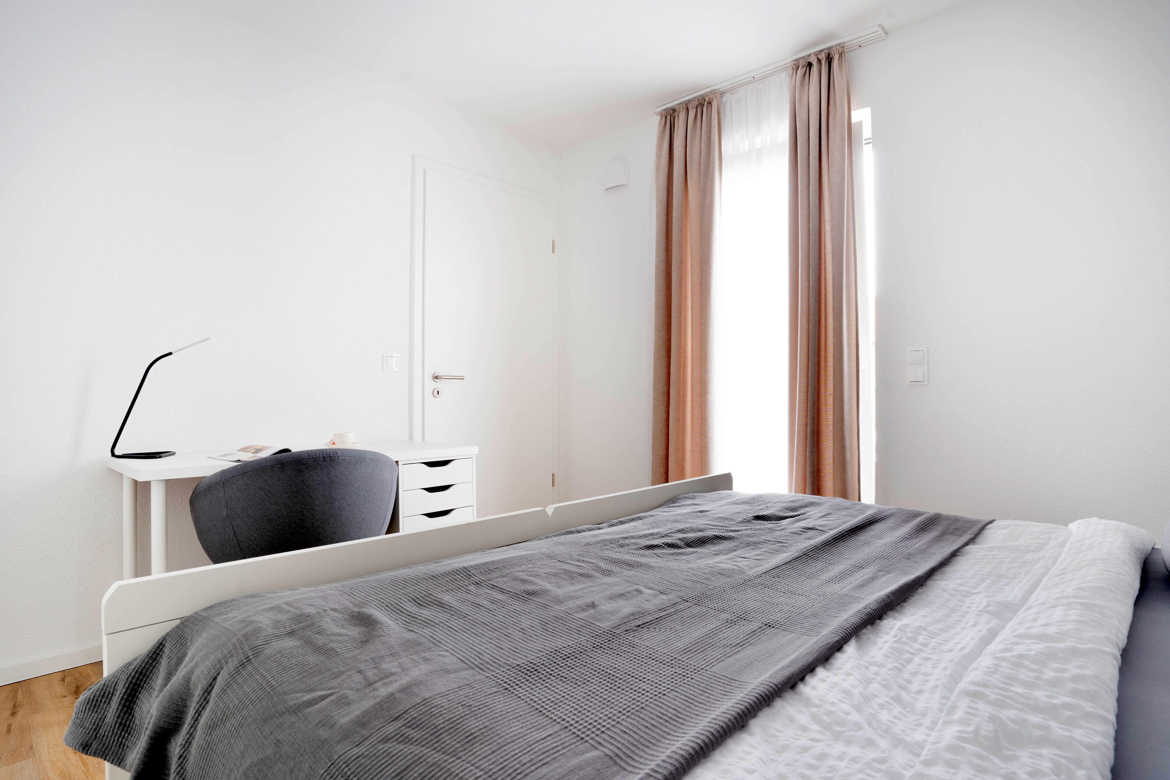 Une chambre à coucher avec un lit, un bureau et une chaise.