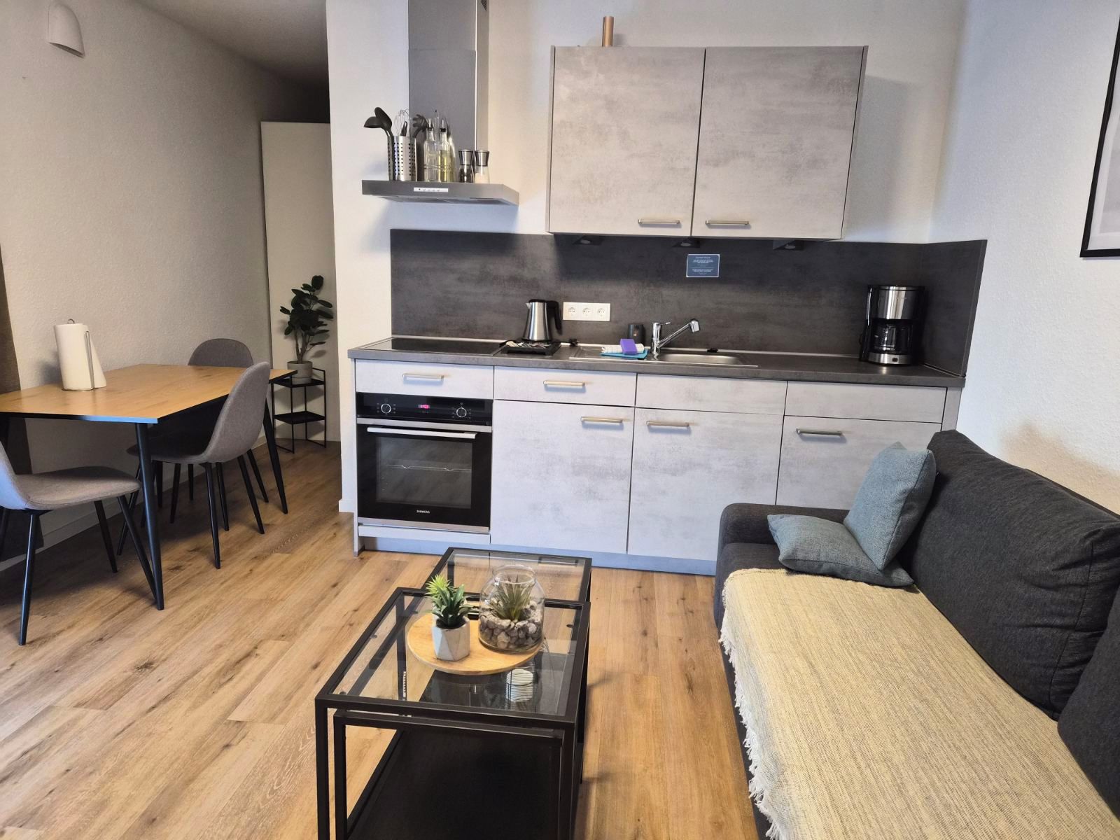 A compact living space with a kitchenette, dining area, and seating area.