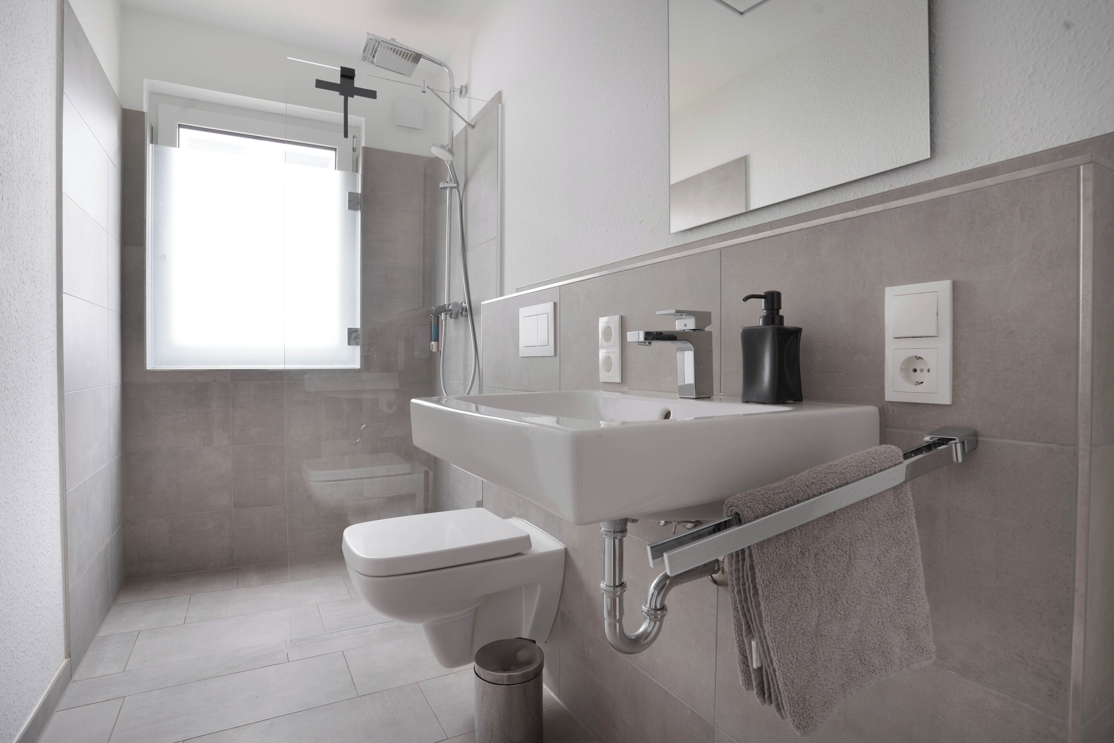 Un baño moderno con ducha, inodoro y lavamanos.