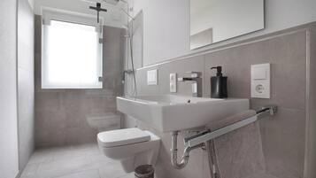 Un baño moderno con ducha, inodoro y lavamanos.