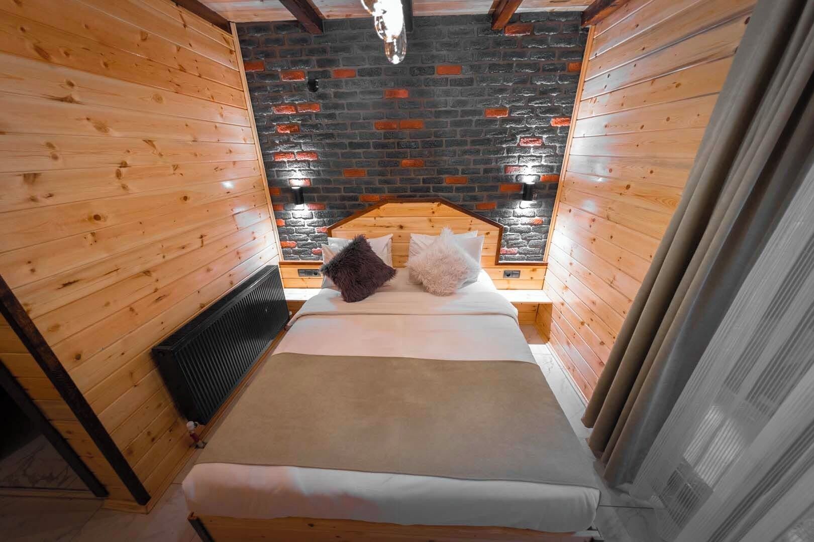 A cozy room with wooden walls and a brick-patterned ceiling.