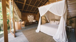 Une chambre avec un lit sous un dais, un bureau en bois et une chaise.