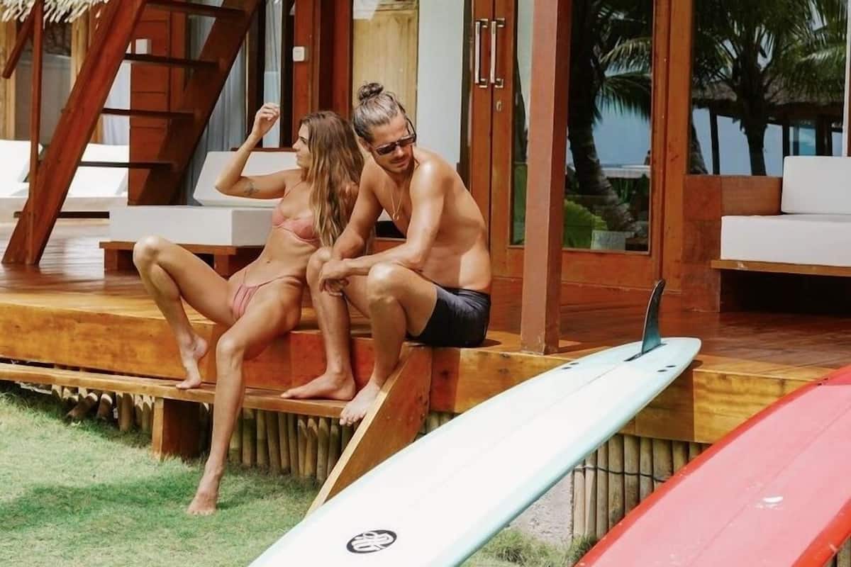 A wooden building with a covered outdoor seating area and two surfboards.