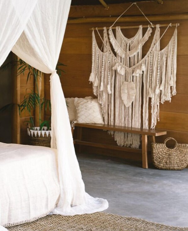 A bedroom with a bed, a macrame wall hanging, and a woven basket. - Awera Resort & Spa (Pototogat Island)