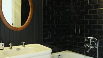 A bathroom with a white sink, a mirror, and a bathtub.