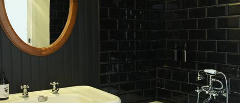 A bathroom with a white sink, a mirror, and a bathtub.