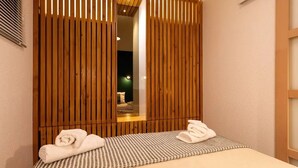 A room with a bed, a wooden partition, and a mirror. - T2 Large terrace with sea view & direct access to the beach – Collioure sector (Port-Vendres)