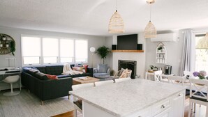A modern kitchen with a marble island, white cabinetry, and pendant lighting. - Short Walk to Cape Ann's Best Beaches! (Gloucester)