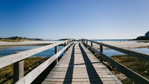 A wooden boardwalk leading to a beach with clear skies. - Short Walk to Cape Ann's Best Beaches! (Gloucester)
