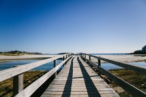 A wooden boardwalk leading to a beach with clear skies. - Short Walk to Cape Ann's Best Beaches! (Gloucester)