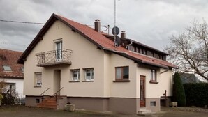 A two-story house with a balcony, a satellite dish, and a chimney. - Vacation home rental near Colmar (Wickerschwihr)