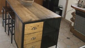 A kitchen with a wooden island, black cabinets, and a radiator. - Vacation home rental near Colmar (Wickerschwihr)