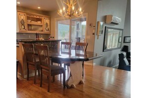 A kitchen with a dining table, chairs, and a chandelier.