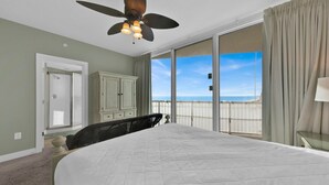 A bedroom with a large bed, a ceiling fan, a view of the ocean, and a sliding glass door to the balcony. - ☀️Beachfront-Corner Unit-Pool-Balcony-Palazzo 408☀️ (Panama City Beach)