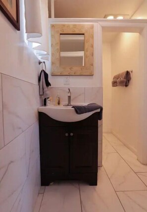 Bathroom with a vanity, mirror, and towel rack.