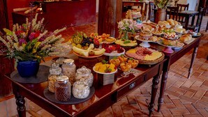 A buffet table with various food items and a potted plant.
