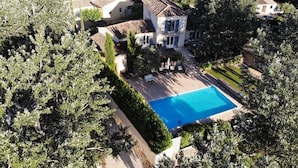 An aerial view of a property with a swimming pool, surrounded by lush greenery and multiple buildings. - Villa de Charme, à Proximité Immédiate D'uzes et du Pont du Gard (Argilliers)
