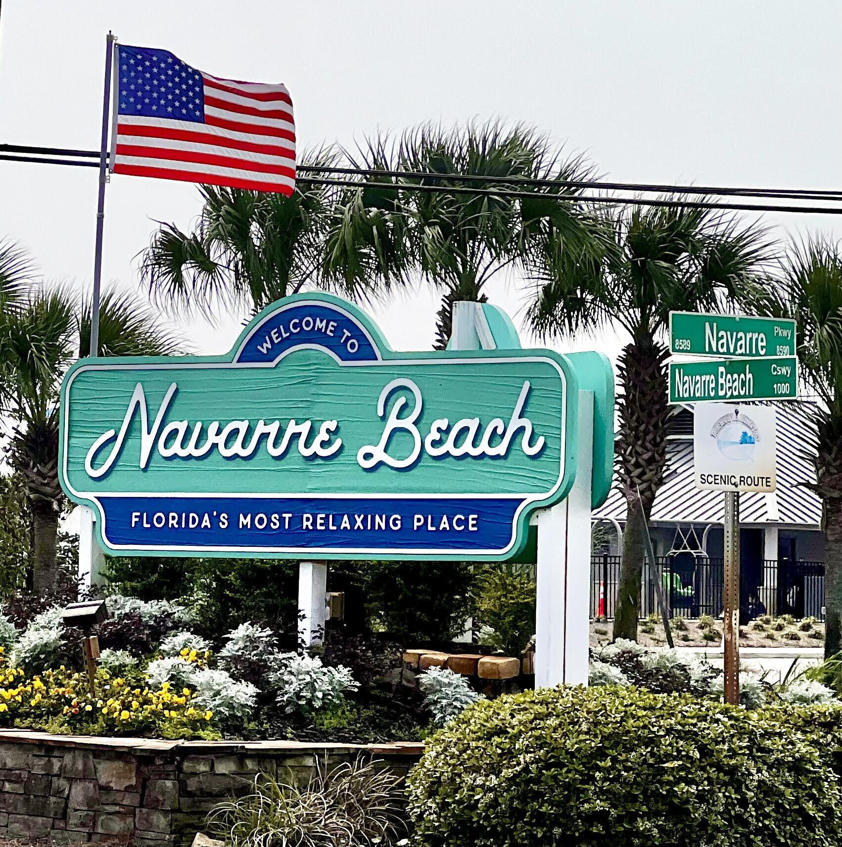 Schild für Navarre Beach, Florida, mit einer amerikanischen Flagge und einem Willkommensschild.