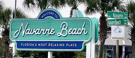 Schild für Navarre Beach, Florida, mit einer amerikanischen Flagge und einem Willkommensschild.