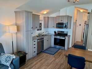 A compact kitchen with a microwave, stove, and dishwasher.