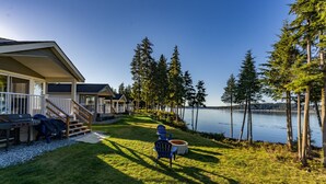 Une propriété située au bord du lac, dotée d’un patio couvert, d’un espace salon extérieur et offrant une vue sur le lac.