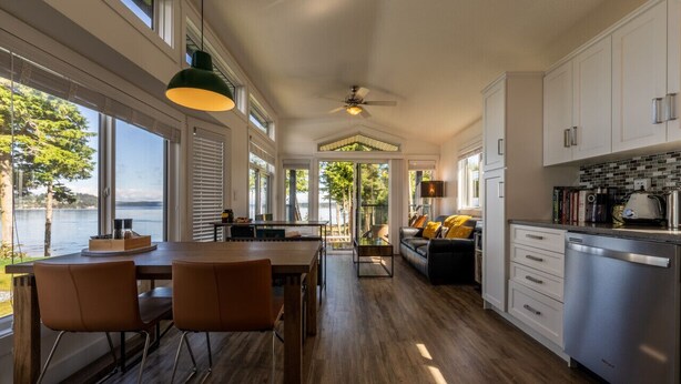 Une cuisine spacieuse avec vue sur le lac, un plancher en bois et des appareils électroménagers modernes.