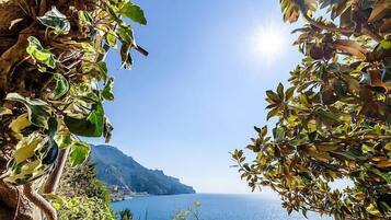 A coastal view with a clear sky, a body of water, and a mountainous landscape in the distance.