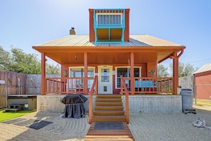 Ein zweistöckiges Haus mit Veranda, einer Haustür und einer Treppe, die zum Eingang führt.