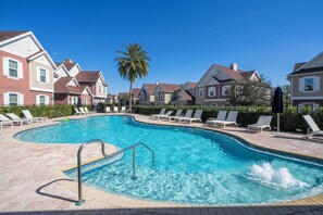 A swimming pool with lounge chairs and a palm tree.