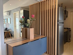 A modern kitchen with a built-in refrigerator, wooden paneling, and a blue cabinet.
