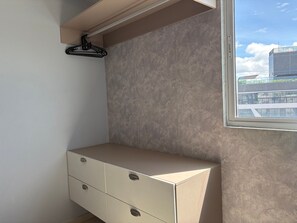 A room with a built-in bench, a window with a view of buildings, and a wall-mounted hanger. - Imperial Bessa (João Pessoa)