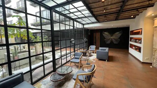 A spacious room with a high ceiling, large windows, and a modern interior design. - R4/ Artistic Loft in historic Candelaria (Bogotá)