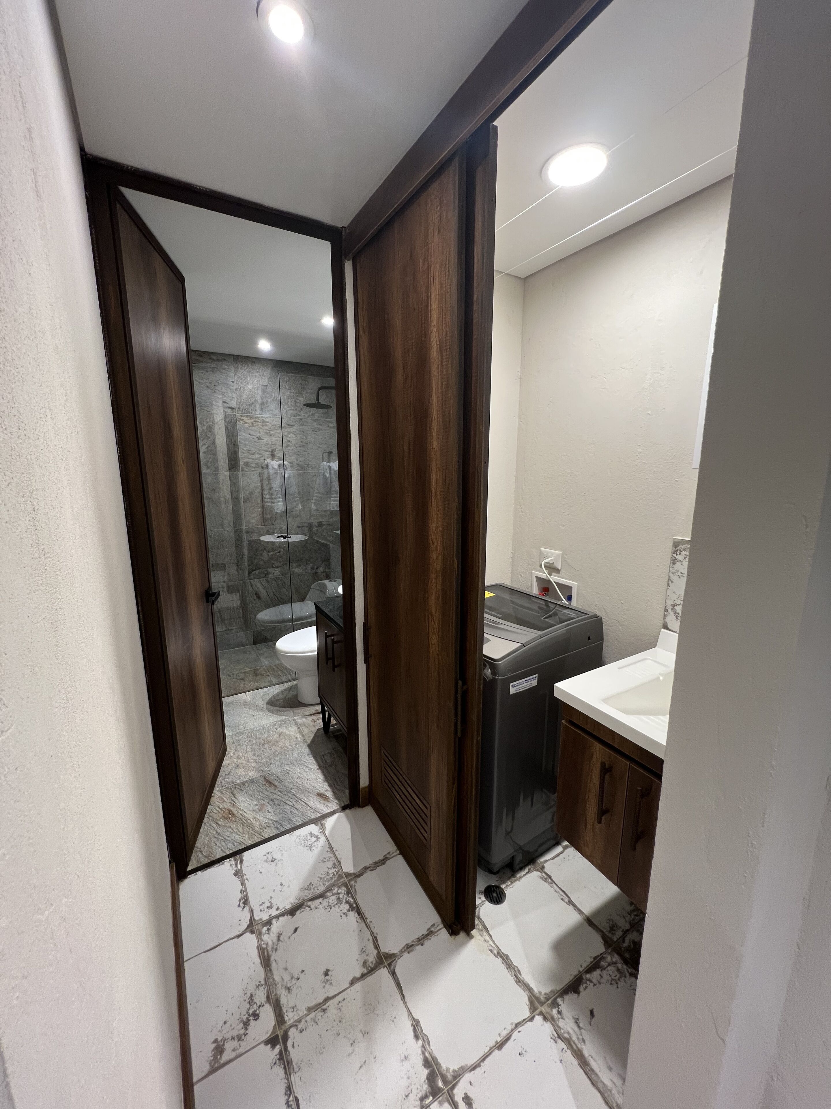 Une salle de bain avec douche, toilettes et lavabo.