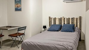 A bedroom with a bed, a desk, and a chair. - Cozy apartment in Ginasservis with swimming pool (Ginasservis)
