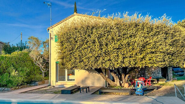 A house with a swimming pool, a stone wall, and a tree in front. - Cozy apartment in Ginasservis with swimming pool (Ginasservis)
