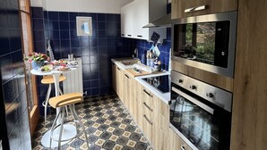 Une cuisine moderne avec des carreaux bleu foncé, des armoires en bois et un sol à motifs.