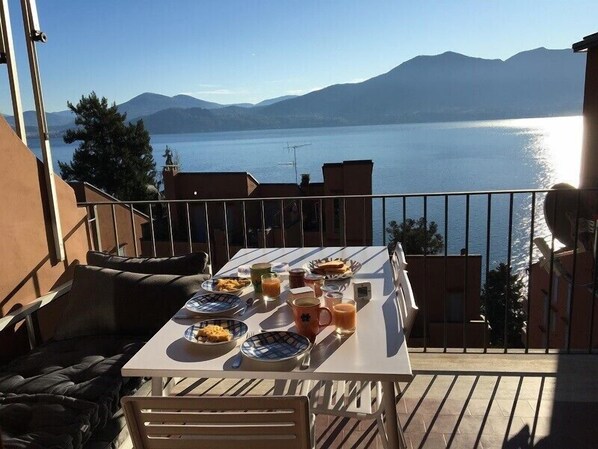 Enjoy a meal on the balcony with a view of the surrounding mountains and water.