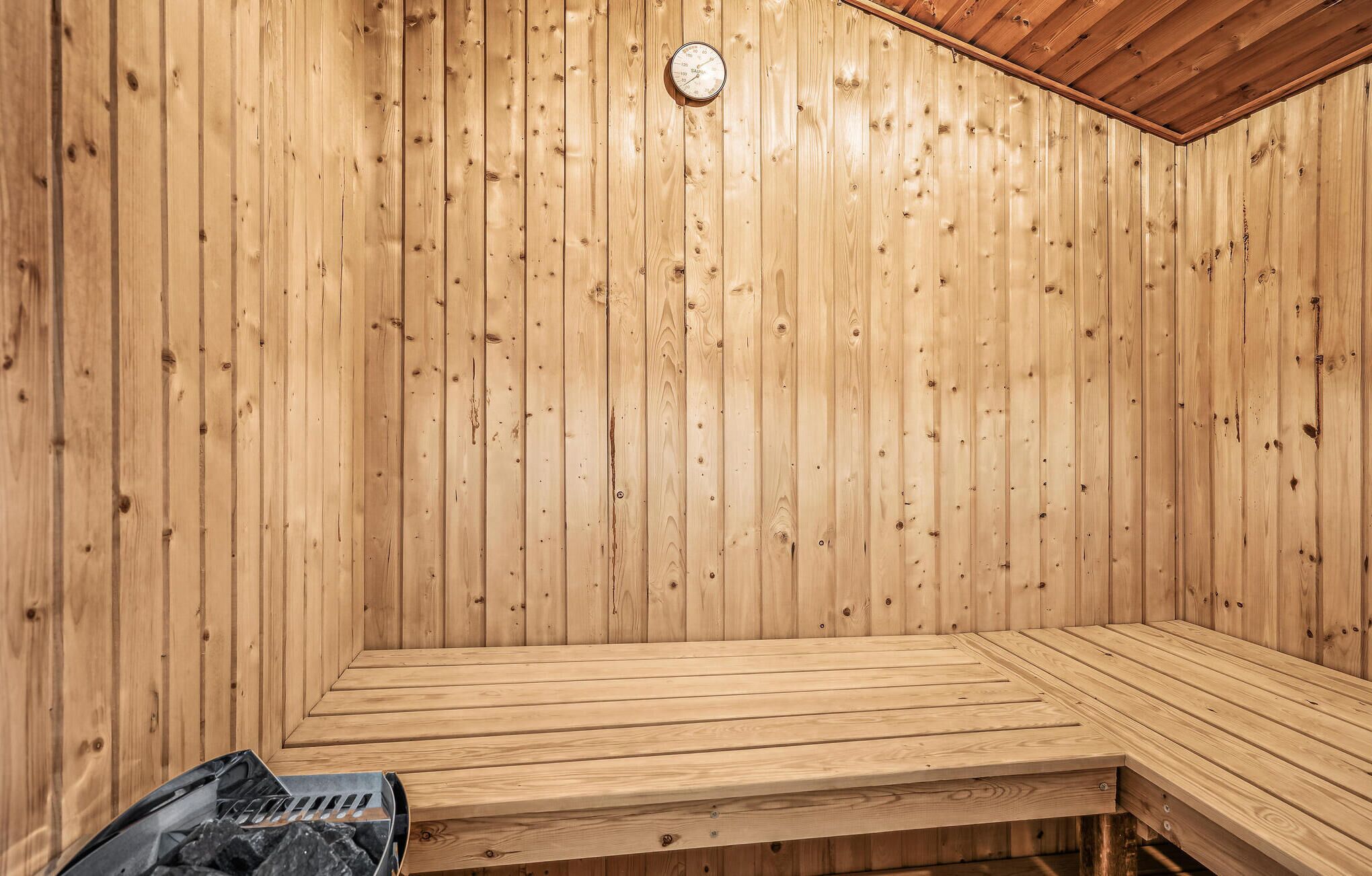 Un sauna avec des murs en bois et un banc.