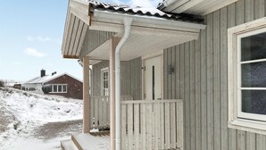 Et træhus med veranda og et vindue.
