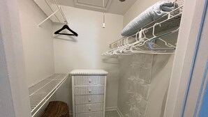 A compact storage room with a built-in bench, a wicker basket, and a white wicker chest of drawers. - Delightful, 4BR 2.5BA ranch style near Parks, trails, shops, malls, Restaurants. (Lithonia)