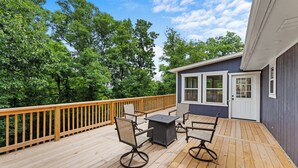 A wooden deck with outdoor furniture, a small building with a door and windows, and a wooden railing. - Beaver Lake Getaway-15 min from downtown Rogers with HOT TUB! (Rogers)
