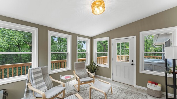 A sunroom with large windows, a ceiling light, and a view of the deck. - Beaver Lake Getaway-15 min from downtown Rogers with HOT TUB! (Rogers)