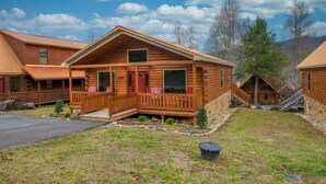 Eine Reihe von Blockhütten mit Veranda, Stein Fundament und einem Rasen.