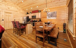 Cozy cabin-style accommodation with a dining table, kitchenette, and seating area.