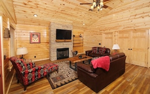 Cozy living room with a fireplace, flat-screen TV, and comfortable seating area.